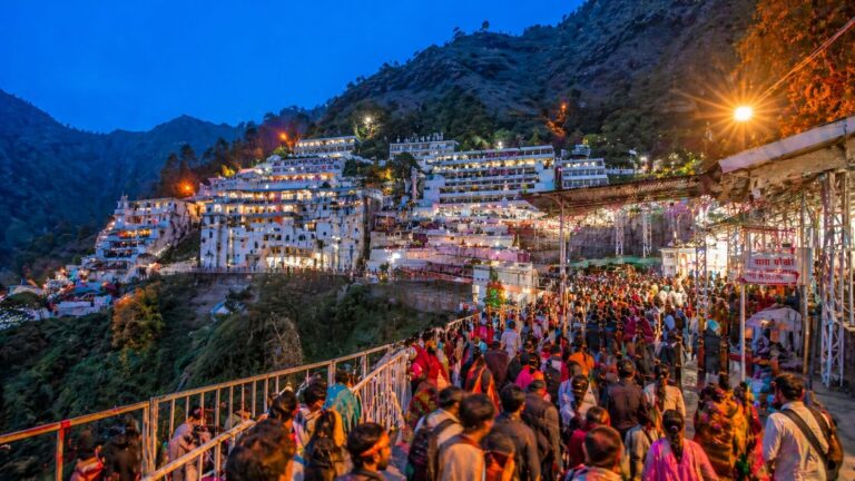 त्रिकुट पर्वत पर स्थित वैष्णो देवी भवन का शाम का दृश्य, जहां रोशनी से सजा मंदिर परिसर और बड़ी संख्या में भक्त दर्शन के लिए जाते हुए दिखाई दे रहे हैं
